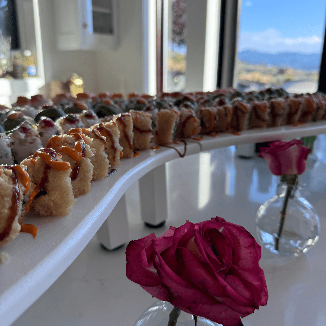 Guests gathered around a glowing Sushi River table with colorful rolls
